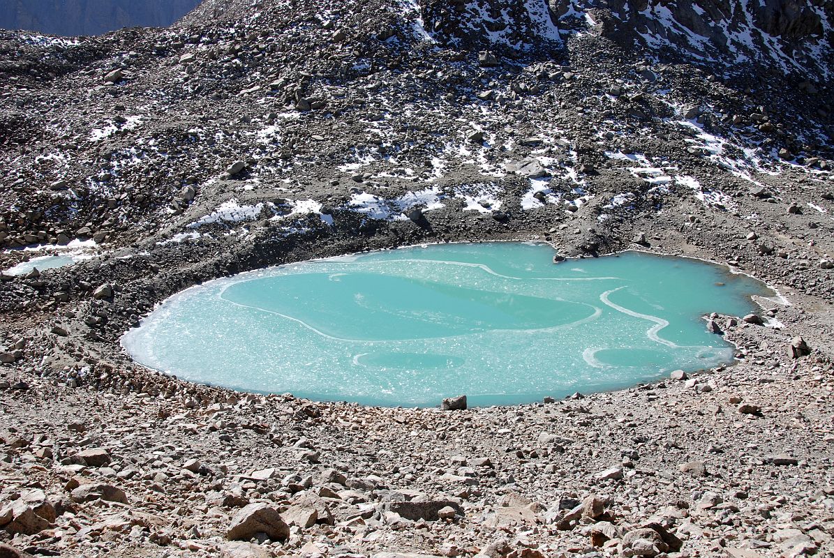 55 Emerald Gaurikund Lake Just After the Dolma La On Mount Kailash Outer Kora Just after the Dolma La, the trail descends steeply to the emerald lake called Gaurikund by the Hindus. Hindus are supposed to take a ritual bath here, a baptism into their new life. The Tibetans call it Tukji Chenpo Tso, the lake of compassion.